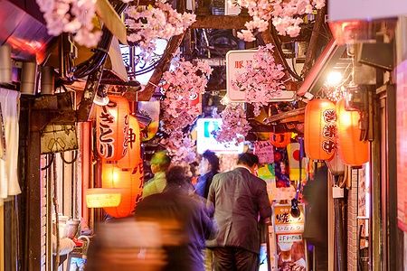 Passeggeri camminano tra lanterne e ciliegi nella Memory Lane a Shinjuku.