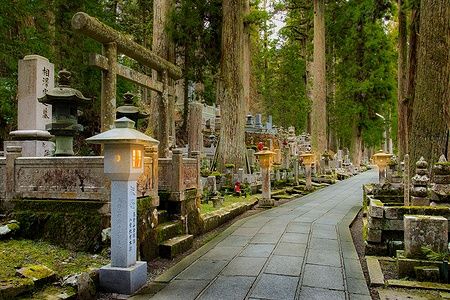 Sentiero serale nel cimitero di Okunoin a Koyasan, con lanterne e tombe.