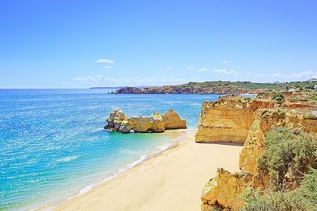 Praia da Rocha a Portimão con sabbia dorata e rocce sotto il cielo blu.