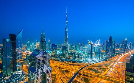 Skyline di Dubai al tramonto con le luci della città e la Sheikh Zayed Road.