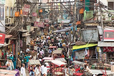 Strade caotiche e affollate di Old Delhi, India, con persone e risciò.