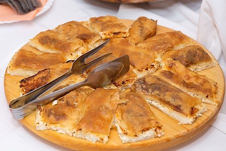 Piatto di legno con štrukli croati a fette.