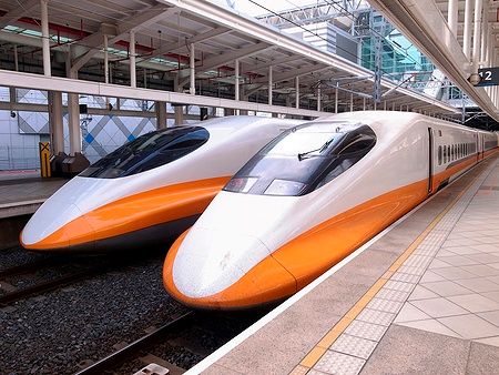 Due treni ad alta velocità parcheggiati alla stazione ferroviaria.