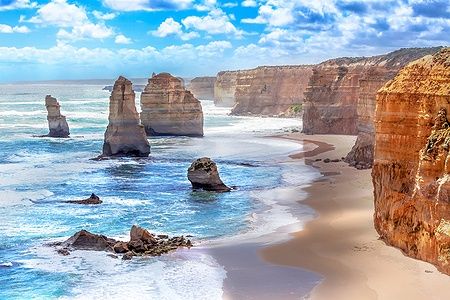 Faraglioni dei Twelve Apostles lungo la Great Ocean Road in Australia con scogliere arancioni e oceano.