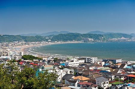 Vista panoramica di Yuigahama Beach a Kamakura, case colorate e spiaggia affollata.