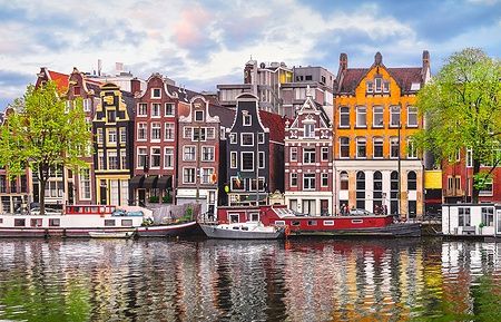 Case danzanti di Amsterdam riflettenti sul fiume Amstel.