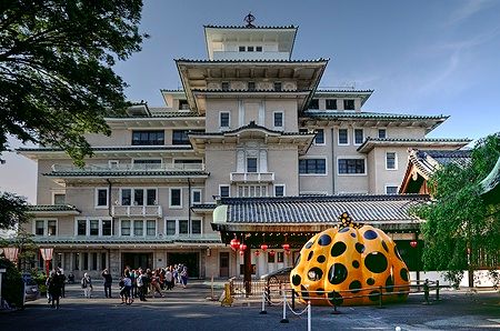 Edificio Gion Corner a Kyoto con una grande zucca gialla a pois neri davanti.