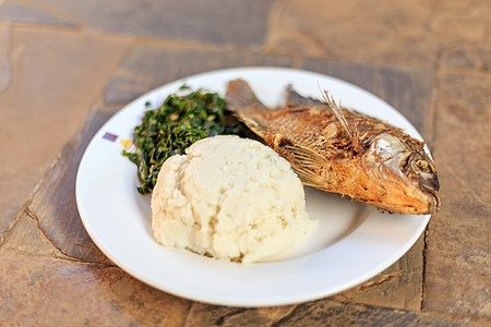 Piatto di ugali, pesce fritto e verdure, tipico della cucina africana.