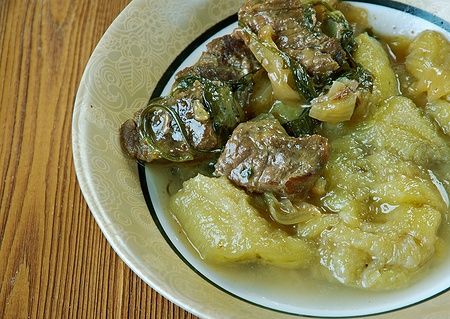 Piatto di Kenyan Matoke con banane da cucina e carne in sugo.