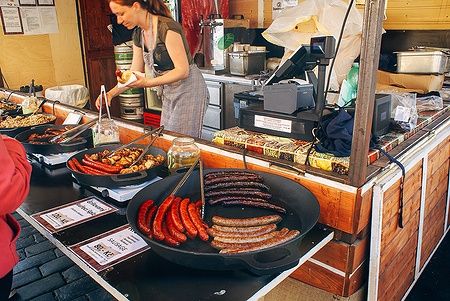Donna che vende carne affumicata in un mercato a Praga.