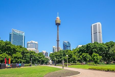 Sydney Tower e Hyde Park a Sydney con cielo azzurro e grattacieli sullo sfondo.