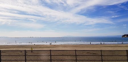 Spiaggia di Yuigahama in Giappone con persone sotto il sole.
