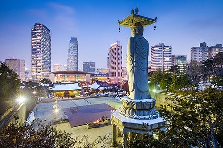 Statua al tempio Bongeunsa con lo skyline di Seoul sullo sfondo.