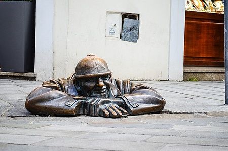 Statua in bronzo di un operaio che spunta da un tombino a Bratislava.
