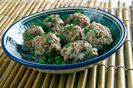 Polpette di Bakso di pollo in una ciotola su un tappetino di bambù.