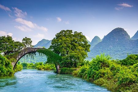 Dragon Bridge di Yangshuo sul fiume Li con montagne sullo sfondo.