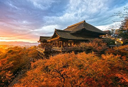 Il tempio Kiyomizu-dera a Kyoto con foglie autunnali al tramonto.