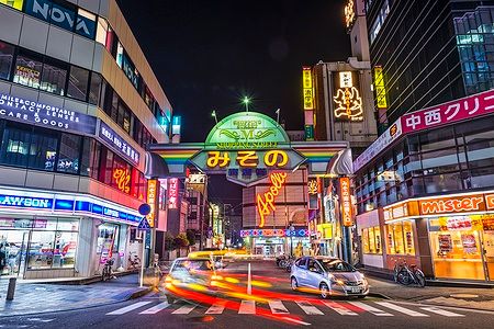 Strada notturna con insegne al neon nel distretto di Misono, Wakayama.