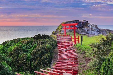 Torii rossi al Motonosumi Inari Shrine in Giappone con vista sull'oceano.