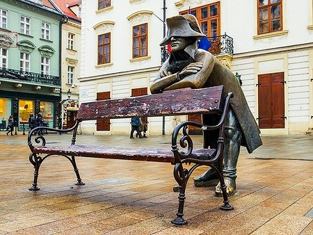 Scultura in bronzo di Napoleone su una panchina in una piazza di Bratislava, Slovacchia.