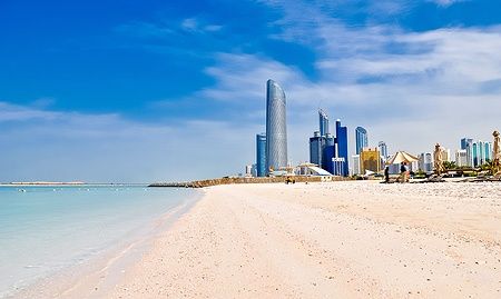 Spiaggia assolata e skyline di grattacieli ad Abu Dhabi, UAE.