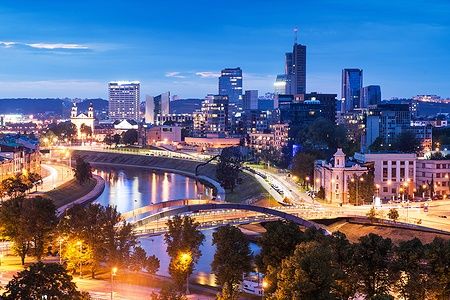 Veduta notturna di Vilnius con grattacieli, ponte Mindaugas e fiume Neris.