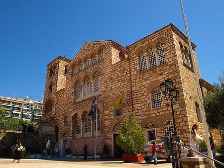 La chiesa di Agios Dimitrios a Salonicco sotto un cielo azzurro con visitatori.
