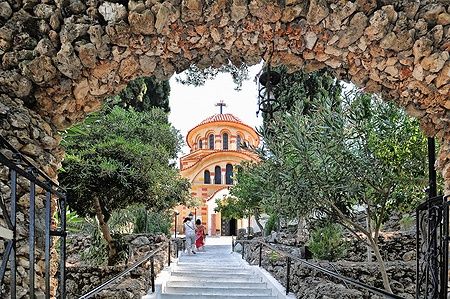 La chiesa di Agios Nektarios a Rodi vista attraverso un arco di pietra.