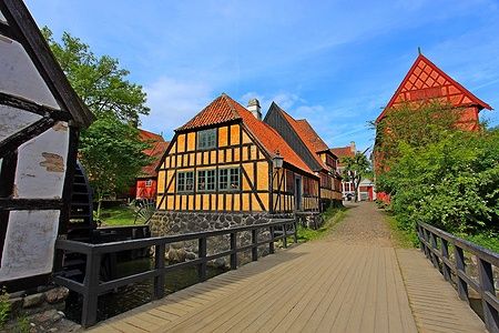 Strada acciottolata con case tradizionali in legno nella città vecchia di Aarhus, Danimarca.