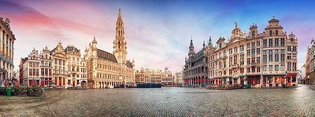 Grand Place di Bruxelles in una giornata estiva con edifici storici e cielo colorato.