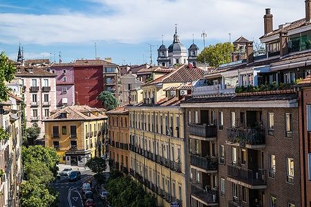 Veduta del quartiere La Latina a Madrid con edifici storici e cupole sullo sfondo.