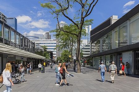 Persone che camminano nella Lijnbaan, via dello shopping a Rotterdam in una giornata di sole.