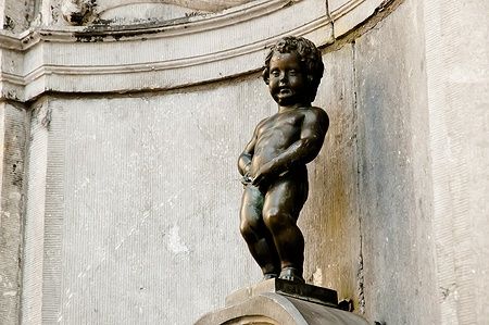 Statua del Manneken Pis a Bruxelles, un bambino di bronzo urinante.