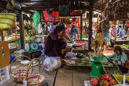 Venditrice al mercato russo di Phnom Penh con merci esposte.