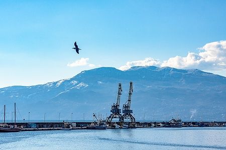 Molo Longo nel porto di Rijeka con gru e montagne sullo sfondo.