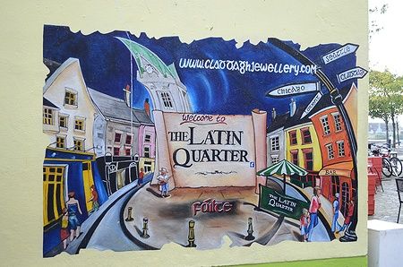 Murale colorato nel Latin Quarter di Galway, Irlanda, raffigurante edifici e segnaletica.
