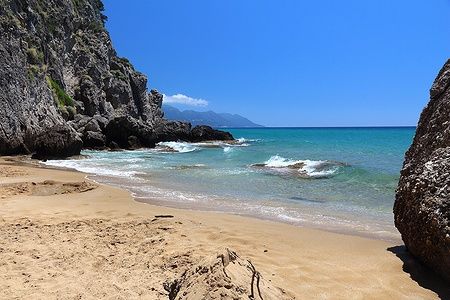 Myrtiotissa Beach a Corfù, con sabbia dorata, scogliere e mare turchese.