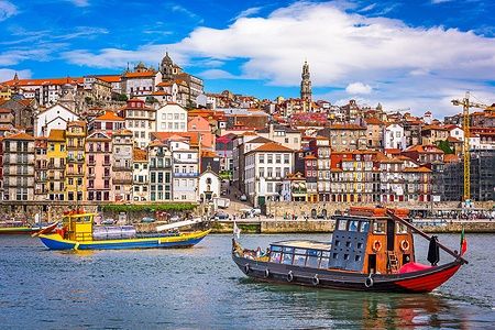 Vista della città vecchia di Porto dal fiume Douro con barche tradizionali.