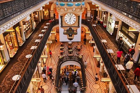 Interno del Queen Victoria Building a Sydney con un grande orologio e gallerie piene di negozi.