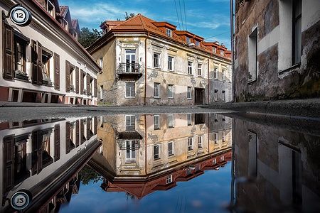 Strada di Uzupis a Vilnius con edifici riflessi in una pozzanghera.
