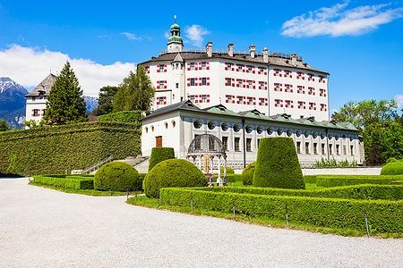 Schloss Ambras a Innsbruck con giardini curati e cielo azzurro.