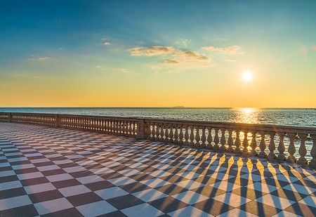 Tramonto sulla Terrazza Mascagni a Livorno, con pavimento a scacchiera e mare.