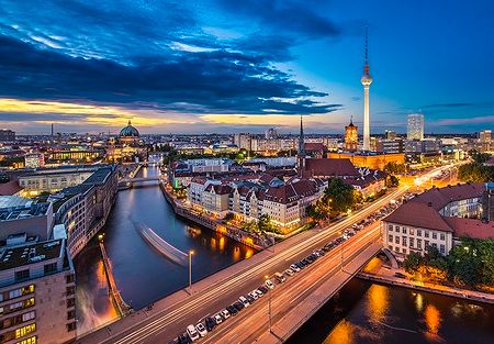 Vista notturna di Berlino sopra il fiume Sprea con la Torre della Televisione illuminata.