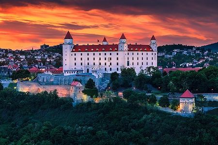 Il castello di Bratislava al tramonto con cielo arancione.
