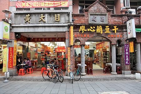 Negozio su Daxi Old Street a Taoyuan, Taiwan, con biciclette e persone sedute.
