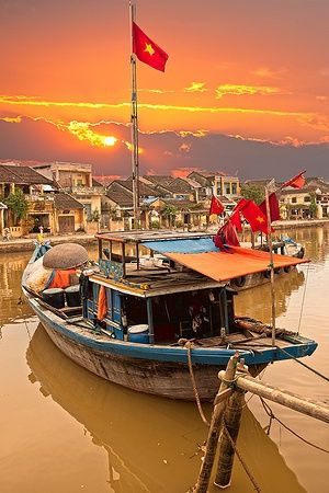 Barca sul canale nella vecchia città di Hoi An al tramonto.