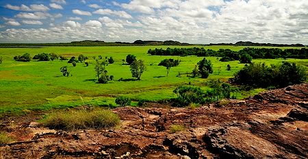Paesaggio verde e roccioso del Kakadu National Park sotto un cielo nuvoloso.