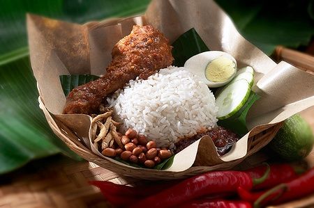 Nasi Lemak con pollo rendang, riso, arachidi, uova, cetrioli e sambal in un cestino.