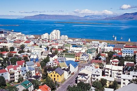 Vista panoramica di Reykjavik, Islanda, con case colorate e mare sullo sfondo.