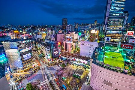 Vista notturna dell'incrocio di Shibuya a Tokyo, illuminato dalle luci della città.